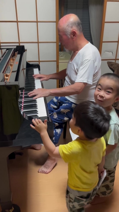 ピアノを弾くおじいちゃんとそれを聞く子どもたち