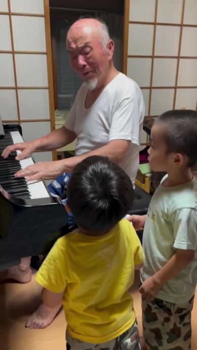 ピアノを弾くおじいちゃんとそれを聞く子どもたち