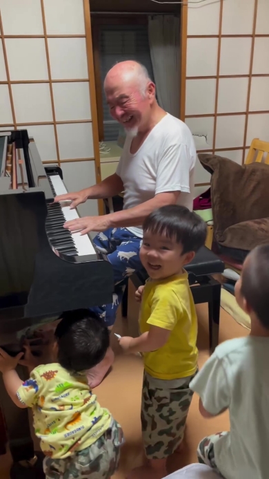 ピアノを弾くおじいちゃんとそれを聞く子どもたち