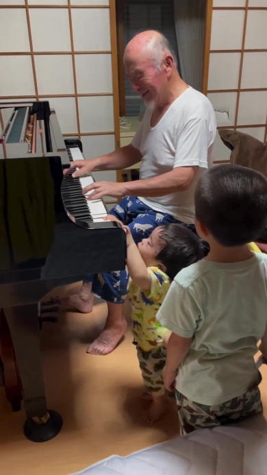 ピアノを弾くおじいちゃんとそれを聞く子どもたち