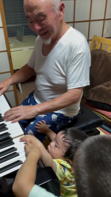 ピアノを弾くおじいちゃんとそれを聞く子どもたち