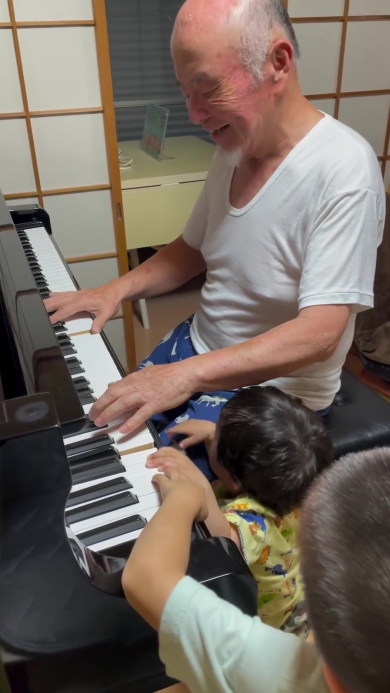 ピアノを弾くおじいちゃんとそれを聞く子どもたち
