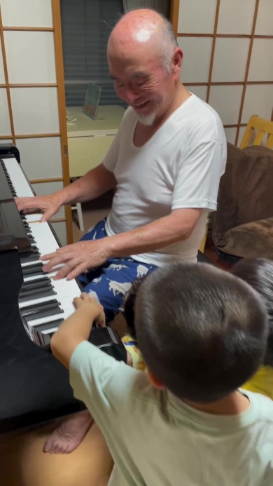 ピアノを弾くおじいちゃんとそれを聞く子どもたち