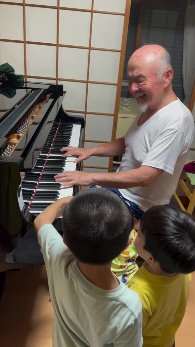 ピアノを弾くおじいちゃんとそれを聞く子どもたち