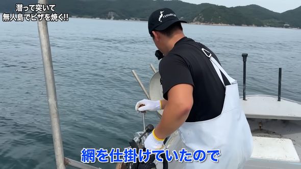 海鮮ピザを作るためしかけていた網を回収する漁師