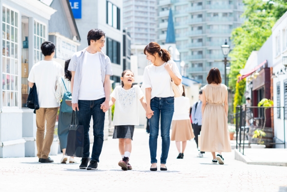 手をつないで歩く家族