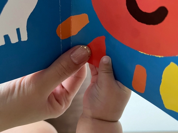 絵本を持つ赤ちゃんの手