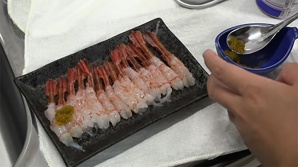 エビに卵を盛りつける様子