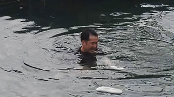 海から頭だけ出す男性