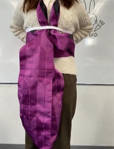 帯を締める女性