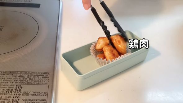 娘のお弁当のために作った鶏むね肉の甘辛炒めを詰めていく
