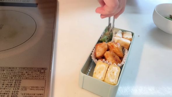 娘のお弁当のために作ったおかずを隙間なく詰めていく