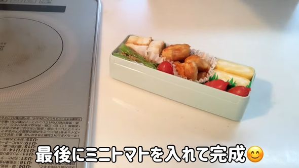 娘のお弁当のためにミニトマトを入れる