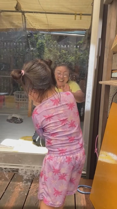 水遊びをする孫とおばあちゃん
