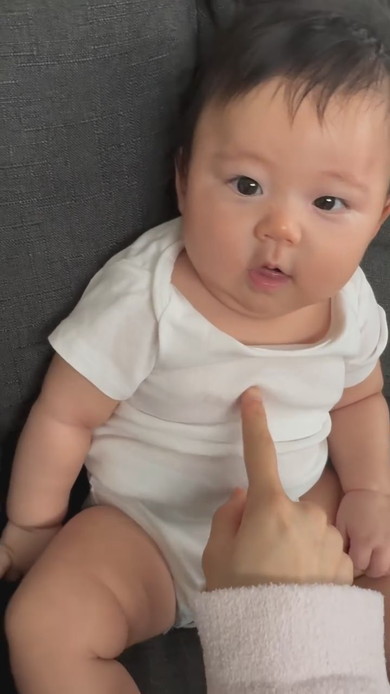 赤ちゃんに指でちょっかいを出すママ