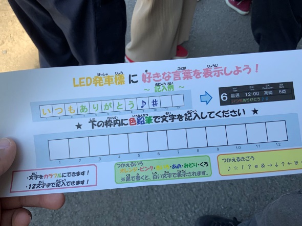 手に文字を記入するための用紙を持つ