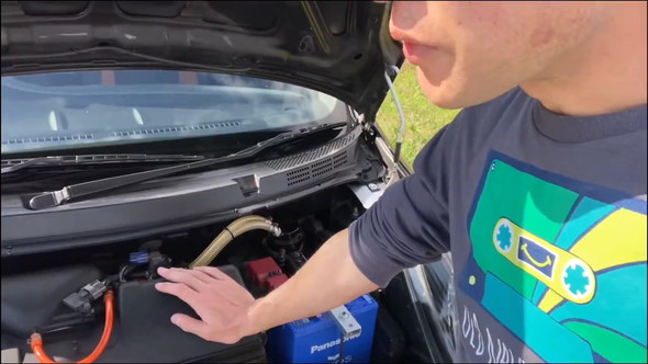 ボンネットを開けて話している男性