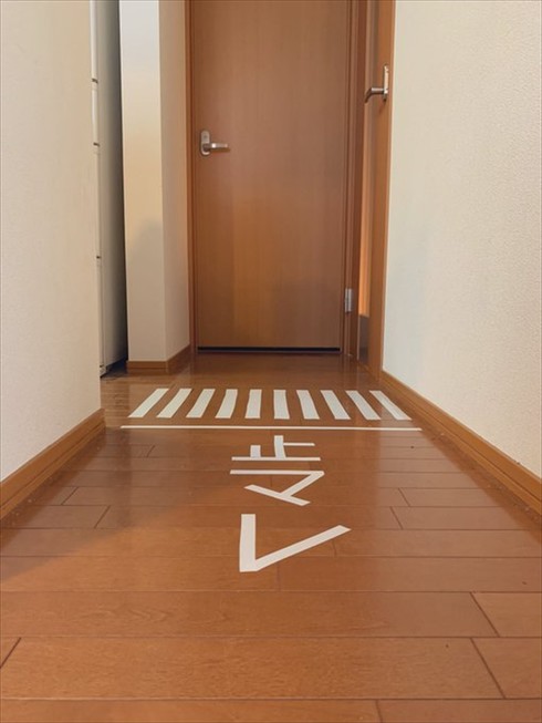 自宅の廊下にビニールテープで作った止マレサイン
