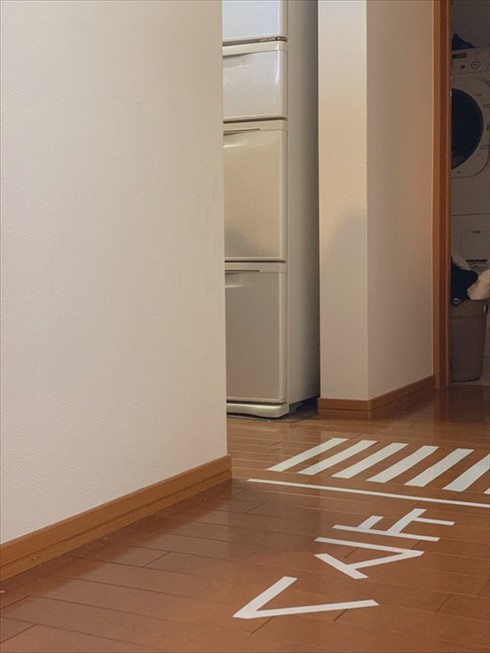 自宅の廊下にビニールテープで作った止マレサイン