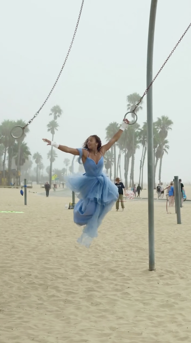 ドレス姿でつり輪する女性