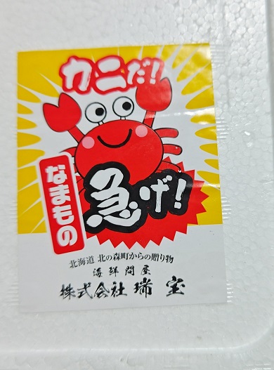 運ぶ人に急ぐよう笑顔で促しているカニのステッカー