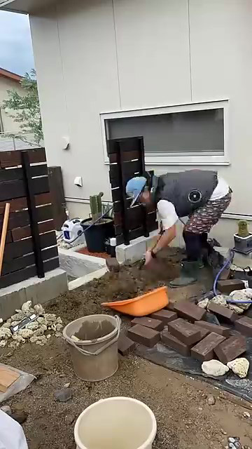 レンガをつむ男性