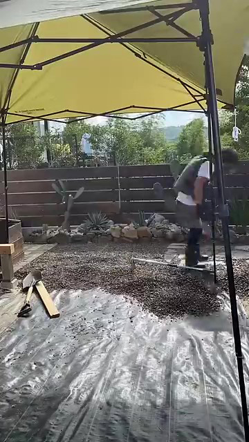 砂利を敷く男性