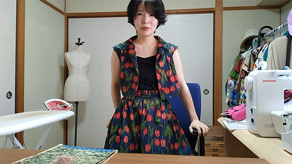 黒いインナーを見せて服を着る女性