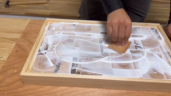 ひっくり返した木箱の中身に接着剤を塗る