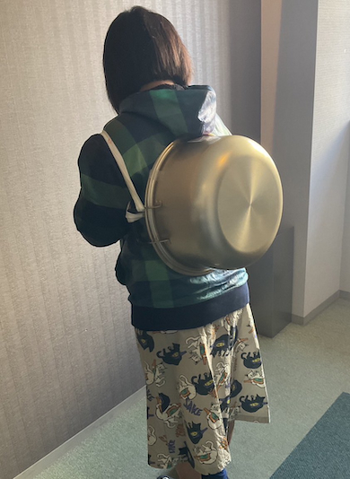 鍋を背負う女性