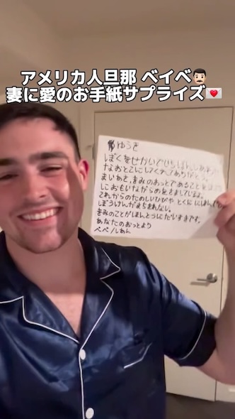 カメラに手紙を見せて笑うイアンさん