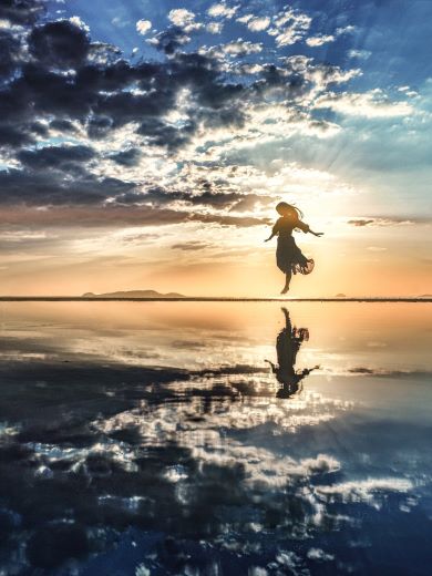 海辺でジャンプする女性