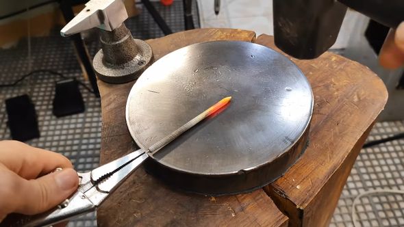 ミニチュアの剣にするため熱したクギをハンマーでたたく