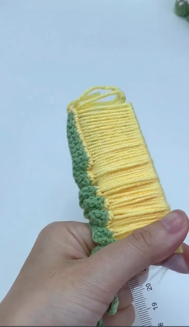 定規から毛糸を外す様子