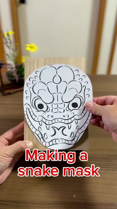 仮面作家が木彫りのヘビの面を作る様子