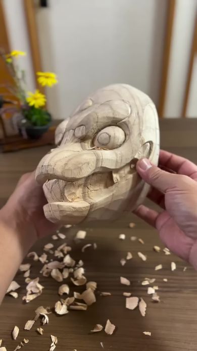 仮面作家が木彫りで形作ったヘビの頭