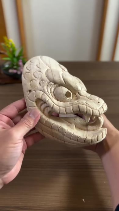 仮面作家が木彫りで形作ったヘビの頭