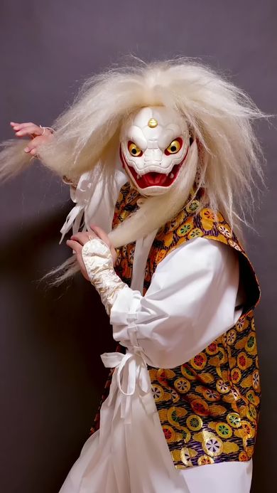 木彫りのヘビの仮面をかぶりヘビらしいポーズを取る