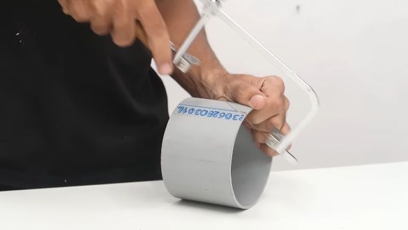 ポリ塩化ビニルの筒をノコギリで半分に切る