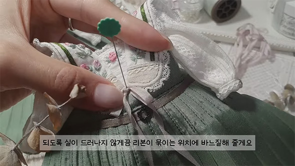 ワンピースにリボンを縫い付ける