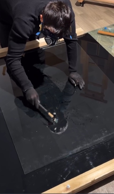 ガラスをハンマーでたたくニール・シュクラさん