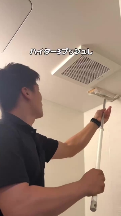 天井をワイパーで拭く男性