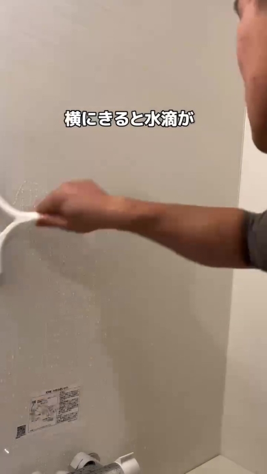 スクイージーで水気を取る男性