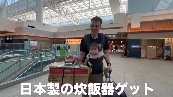 羽田空港で日本製の炊飯器を購入し持ち運ぶ夫