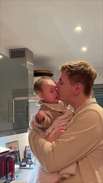 娘の頬にキスするパパ