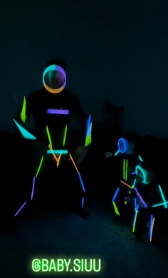 ケミカルライトをつけて踊る親子