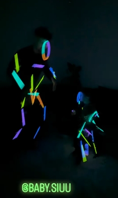 ケミカルライトをつけて踊る親子