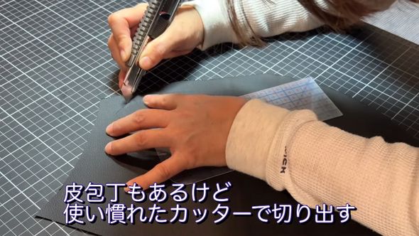型紙を当ててレザー素材から持ち手の革部分を切り出す妻