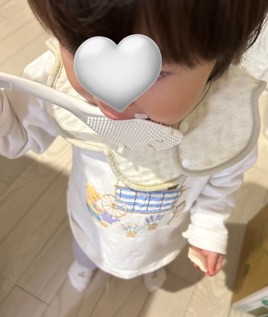 しゃもじから米粒を食べる1歳の女の子