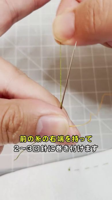 左手で糸と針を抑えて右手で古い糸の右端を針に巻き付ける